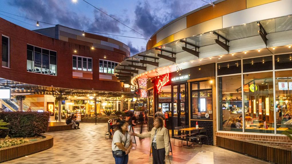 people blurred walking through outdoor shopping mall