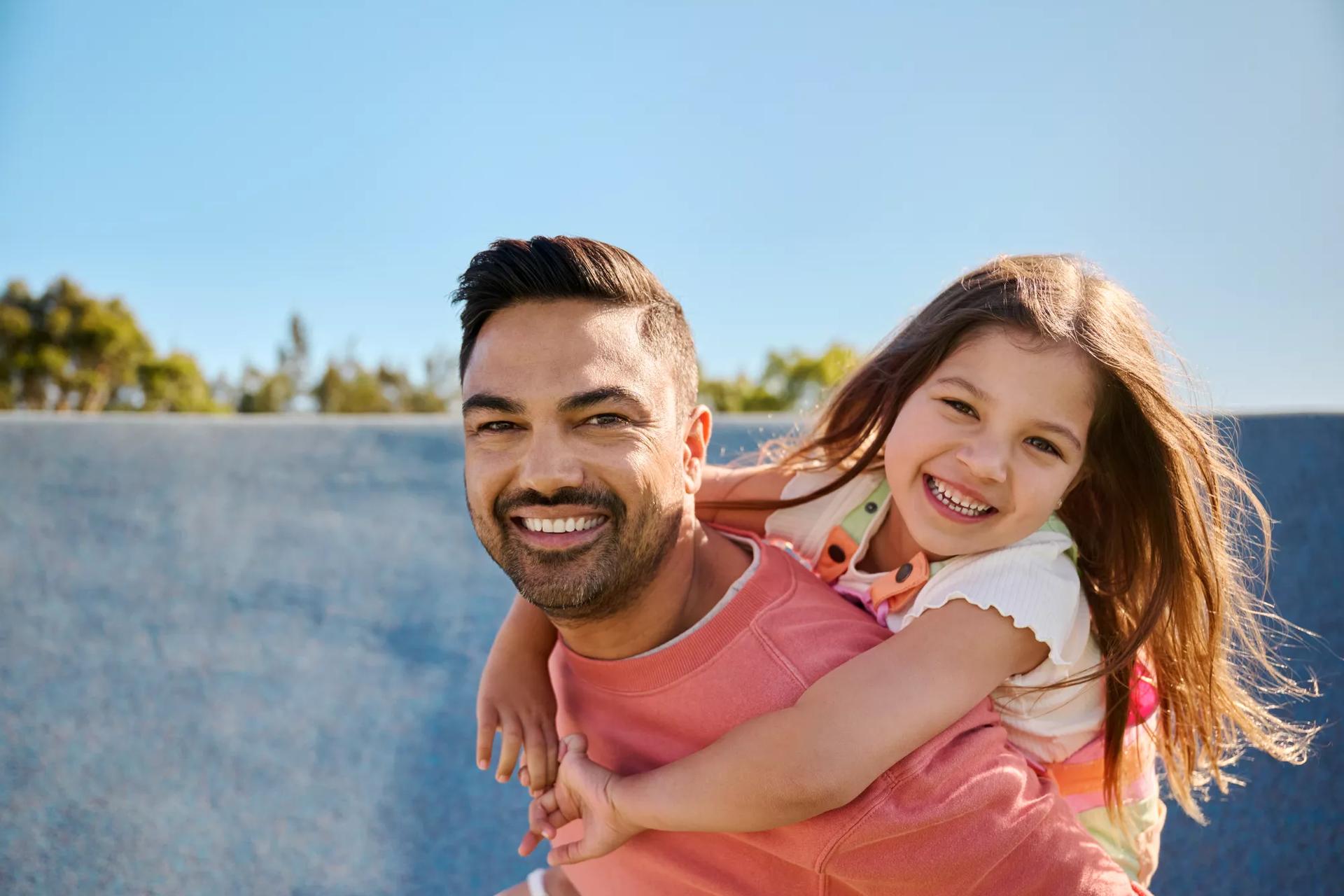 Dad piggybacking daughter