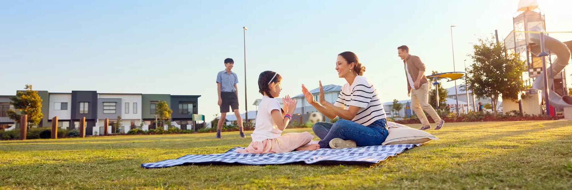 Family playing in the park with homes in the background